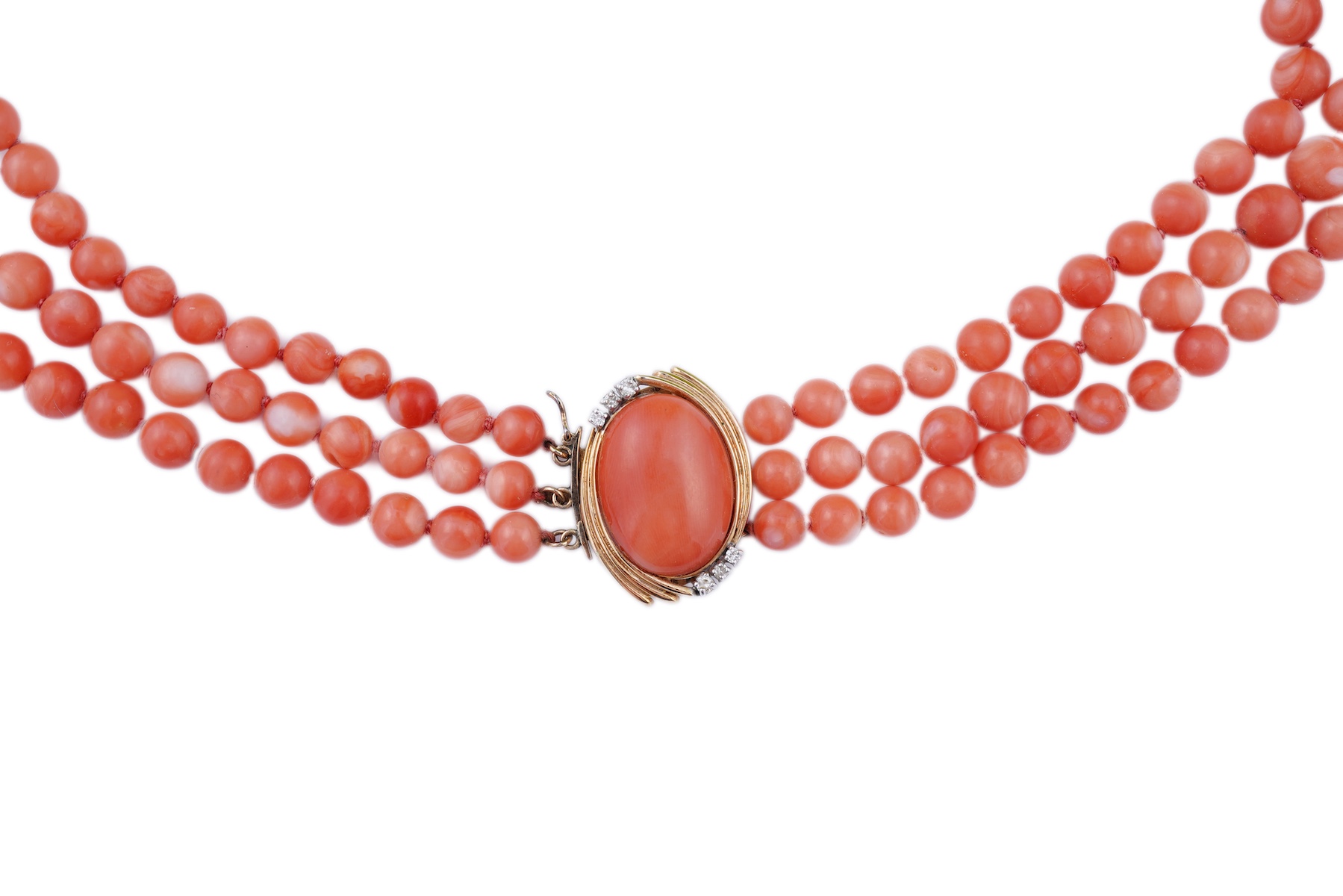 A coral necklace, composed of three strands of coral beads measuring approximately 5.1-6.6mm diameter, to a gold clasp set with a coral cabochon and brilliant-cut diamonds, mounted in gold, length 45.5cm, stamped 14K, ca